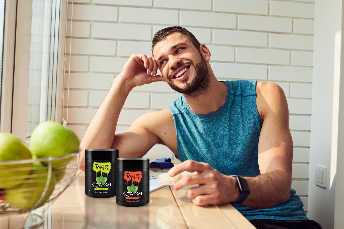 Person sitting at a table with two containers labeled 'Doojee Kratom'.